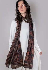 Bufanda de patrón floral oscuro con rayas, hecha de una tela ligera y transparente. Presenta colores marrón y negro con intrincados detalles florales.