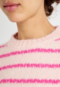 Roze gestreepte gebreide sweater met een zachte textuur, voorzien van felroze en lichter roze strepen, een geribde halslijn en een relaxte pasvorm.