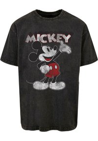 T-shirt en coton noir avec un graphique décoloré de Mickey Mouse et le texte en gras "MICKEY" en blanc et rouge. Manches courtes et col rond.