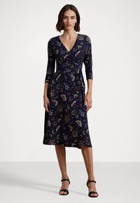 Abito a portafoglio blu navy con motivi floreali in rosso, oro e bianco. Presenta maniche a tre quarti e una gonna di lunghezza media. Tessuto dalla consistenza liscia.