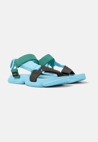 Blue and black sandals featuring adjustable straps in teal and black, a textured footbed, and a curved, lightweight sole.