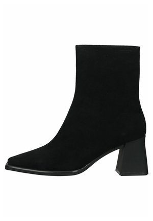 Bottine en daim noir avec un bout pointu et un talon carré épais. Texture lisse avec un minimum de détails et une silhouette élégante.