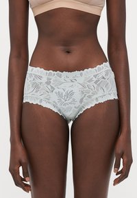 Light blue lace briefs with floral pattern, scalloped edges, and breathable texture, featuring a mid-rise waistband and a snug fit.