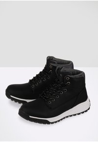 Zwarte hoge sneakers van een glad materiaal, met een textuur grijze kraag, metalen oogjes en een witte tussenzool. Voorzien van een robuuste zwarte zool.