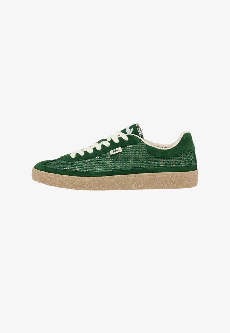 Lage groene sneaker met witte veters, zijpanelen van mesh, een beige textuursola en een klein Lacoste krokodillenlogo aan de zijkant.