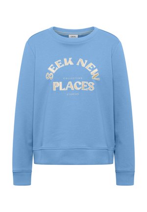 Sudadera azul claro con cuello redondo, puños y dobladillo acanalados, con texto beige "SEEK NEW PLACES" y palabras blancas más pequeñas "COLLECTING STORIES" en el frente.