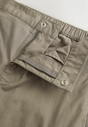 Pantaloni grigi chiari con zip frontale, vita elastica e una texture liscia, con una chiusura a scatto in metallo in vita.