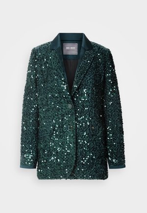 Grønn paljettblazer med en glatt satengrevers, to knapper og sidelommer. Teksturert overflate reflekterer lys, som skaper en glitrende effekt.