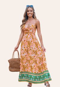 Vestido maxi con estampado floral y escote retorcido. Presenta una combinación de colores en rosa claro y naranja con ribetes verdes y florales. Bolso de tejido.