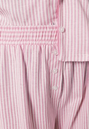 Tissu rayé verticalement rose et blanc avec une couture élastique froncée et une rangée de boutons blancs le long du bord.