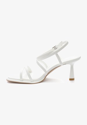 Białe sandały na wysokim obcasie z kwadratowym noskiem, z cienkimi paskami i zapięciem na kostce. Gładki, błyszczący materiał syntetyczny o minimalistycznym designie.