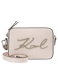 Prostokątna różowa skórzana torba na ramię z metalowym logo oraz odpinanym paskiem o polerowanym wykończeniu i czarnymi akcentami.