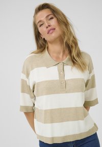 Beige och vit randig bomullspolo med krage och tre-knappars placket. Kortärmad, avslappnad passform, ribbad nederkant.