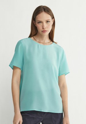 Lys teal kortærmet bluse lavet af glat stof med rund halsudskæring og afslappet pasform. Simpelt design uden mønstre eller detaljer.