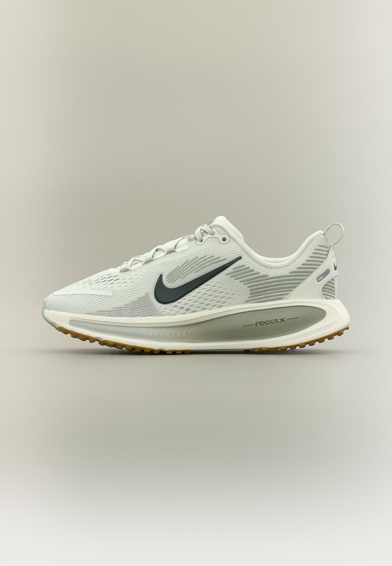 Chaussure de course Nike React blanche avec logo swoosh noir, tige en mesh respirant et semelle amortie avec technologie en mousse React visible.