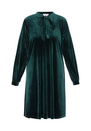 Zöld bársonydressz hosszú ujjal, magas gallérral és megkötő nyakkivágással. Puha textúrájú és lebegő sziluettű, térd hosszúságú design.