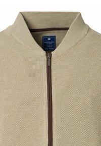 Beżowy sweter z zamkiem błyskawicznym, z prążkowaną teksturą, brązowym zamkiem i kołnierzem. Z metką z napisem "Redmond Casual."