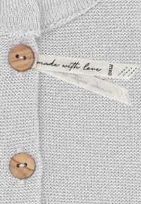 Light gray knit sweater featuring wooden button hardware and a fabric label with the text "made with love" in script.