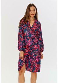 Květinové šaty s volánkovými rukávy, v odstínech námořnické modři se vzory růžových a červených listů, stažené v pase pro přiléhavou siluetu.