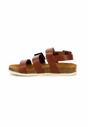 Brown leather sandal with three wide straps, cork insole, and white rubber outsole. Flat design and open back for easy wear.