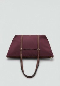 Bordeaux kleurige stoffen draagtas met een ritssluiting, twee bruine leren handvatten en een voorvak. Gladde textuur, minimalistisch ontwerp.