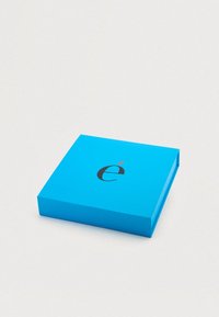Μπλε ορθογώνιο κουτί με λείο, ματ φινίρισμα. Στην κορυφή έχει ένα μαύρο λογότυπο με κόκκινο τόνο πάνω από το γράμμα "e".
