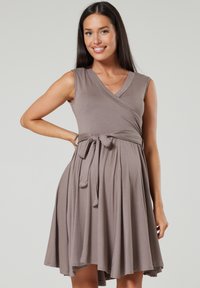 Brown wrap dress made of soft fabric, featuring a V-neckline, sleeveless design, and a tie belt at the waist, flowing skirt.