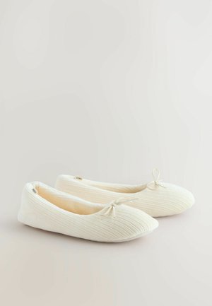 Weiße Ballettschuhe aus geripptem Stoff, mit einer runden Spitze und einer kleinen Schleifenakzent auf der Vorderseite. Weicher, strukturierter Finish.