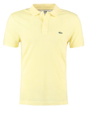 Rumena polo majica iz bombaža s klasičnim ovratnikom, kratkimi rokavi in zelenim logotipom na levi strani prsnega koša, ki ima teksturiran vzorec.