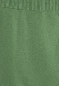 Soft green fabric with a fine knit texture and a ribbed detail at the top edge.