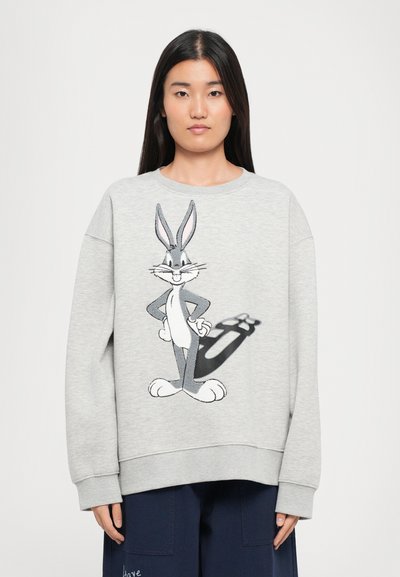 Šedá mikina z měkké látky s velkým, detailním motivem Bugs Bunnyho na přední straně. Zvýšená šířka manžet a lemu pro větší pohodlí.