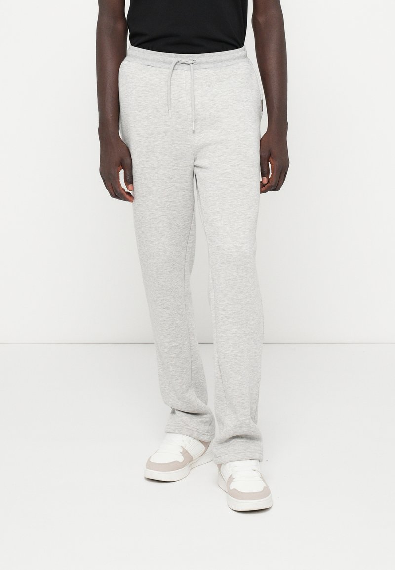 Graue Sweatpants aus weichem Stoff, mit einem elastischen Bund und einem Kordelzug, geraden Beinen und einer dezenten Textur.