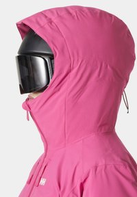 Růžová lyžařská bunda s kapucí, se zipovým uzávěrem a moderním designem. Obsahuje boční kapsy a texturovanou tkaninu.