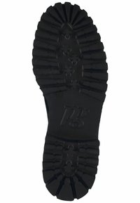 Black rubber sole with deep treads and a textured surface, featuring a logo in the center and horizontal ribbing for traction.