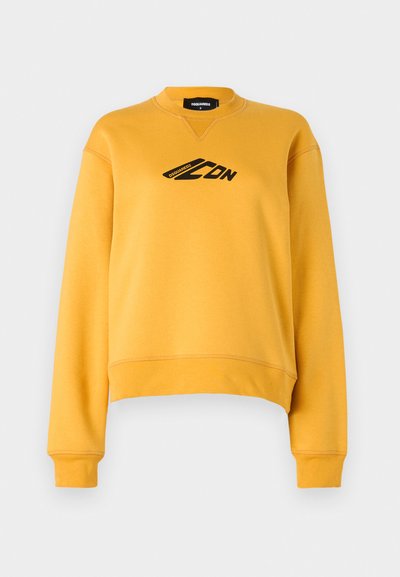 Gul genser med lange ermer og rund hals. Har en svart logo på forsiden. Laget av myk, teksturert stoff. Kuttet hem.
