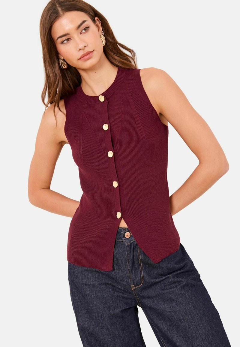 Top bordeaux senza maniche in maglia a coste con scollo rotondo, dotato di sette bottoni color oro lungo il davanti e spacchi laterali.