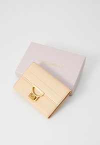 Beige leren portemonnee met een gestructureerde afwerking, voorzien van een gouden sluiting. Inclusief een lichtroze doos met gouden letters.