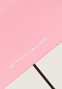 Rosa Regenschirm mit einer glatten Stoffoberfläche, der ein weißes "TOM TAILOR"-Logo und ein schwarzes Metallgestell zur Unterstützung aufweist.