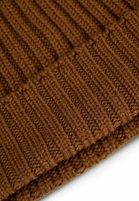 Beanie marrone lavorato a maglia con texture a costine e orlo piegato. Realizzato in filato spesso, presenta un colore uniforme e una cucitura densa.