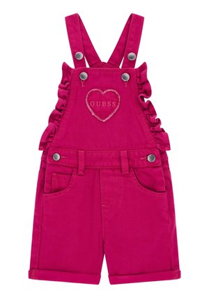 Felroze korte tuinbroek voor peuters met geplooide zijkanten, verstelbare bandjes, zilveren knopen, voorzakken en een hartje met "GUESS" borduurwerk op het slabbetje.