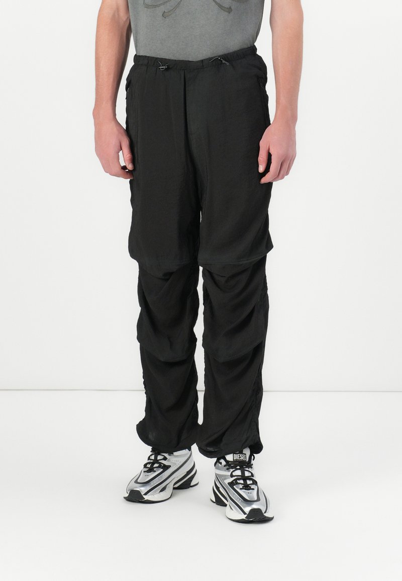 Pantalons légers noirs à coupe ample, dotés d'une taille élastique et d'un cordon de serrage, de coutures froncées et d'une texture lisse.