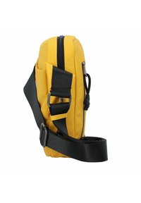 Gelbe Umhängetasche aus strapazierfähigem Stoff, mit einem verstellbaren schwarzen Träger, vorderer Tasche und Reißverschluss. Kompaktes Design.