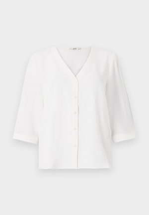 Biała bluzka z dekoltem w serek i sześcioma guzikami z przodu. Posiada rękawy o długości trzy czwarte oraz luźny krój. Miękki, teksturowany materiał.