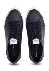 Laivastonsiniset nahkakengät, joissa valkoiset kumipohjat, pyöreä kärki, nauhakiinnitys ja sisäpuolella oleva brändäys mustassa pohjallisessa.