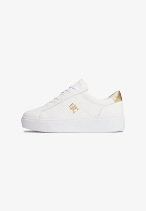 Fehér bőr sportcipők texturált arany díszítéssel a saroknál, lapos fehér talppal és fém logós részlettel rendelkező fűzős elülső résszel.