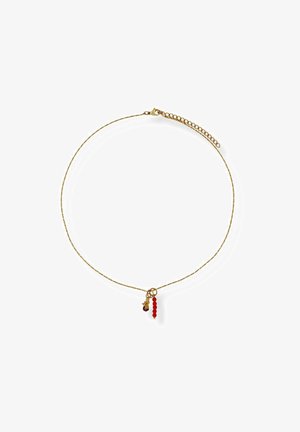 Zarte goldene Halskette mit kleiner roter Perle und sternförmigen Anhängern, die nahe dem Verschluss auf weißem Hintergrund hängen.