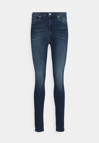 Skinny jeans in dark blue denim with slight fading, five-pocket design, and a front button closure. Smooth texture, fitted silhouette.