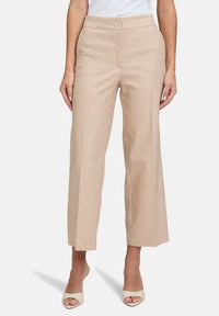 Beżowe spodnie szerokie z delikatnym wzorem pasków, wykonane z gładkiego materiału, z dwoma guziczkami z przodu i dopasowanym krojem.