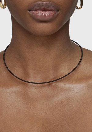 Collar choker negro hecho de un material flexible, con un diseño liso y esbelto que se ajusta cerca del cuello.