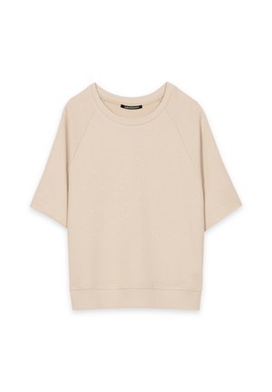 Beige short-sleeve sweatshirt with small silver dot embellishments and a ribbed hem and neckline, flat lay on white background.